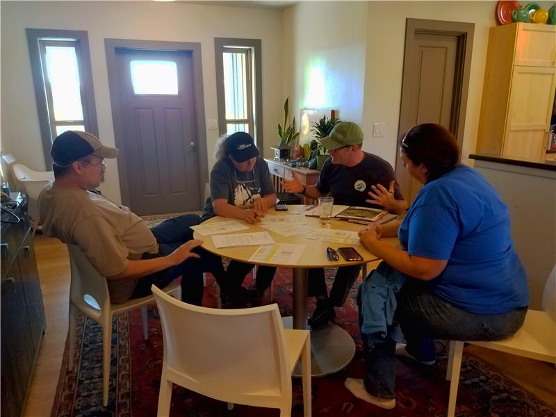 Four people seated around a table inside