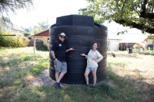 posing in front of a rain harvesting tank